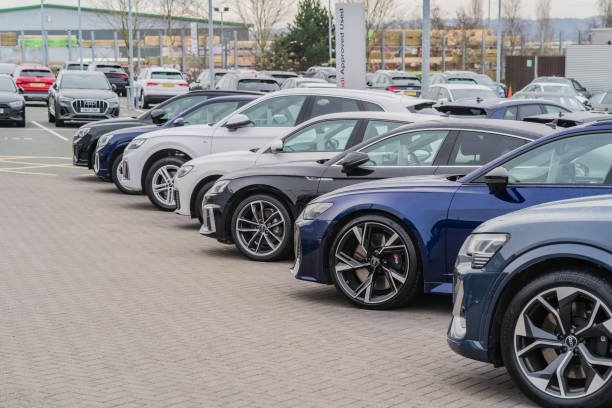 Trentham, Stoke-on-Trent, England, February 10th 2023. A row of Audis parked at a dealership lot, transport and retail editorial illustration.
